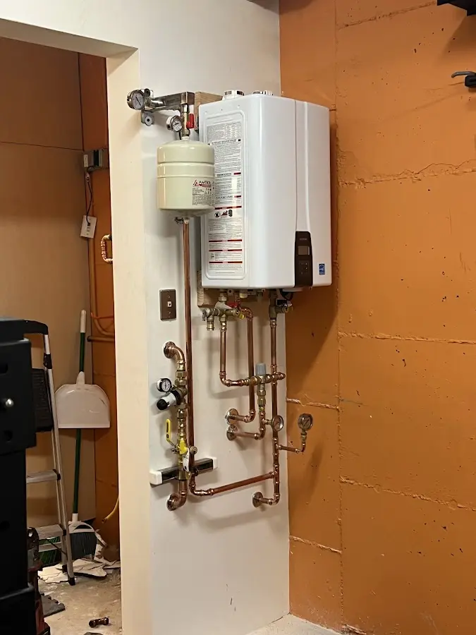 Plumbing technician inspecting water heater connections in Sturgis